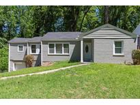 Charming single-story home with gray brick and siding, complemented by a lush green lawn at 2025 Venetian Sw Dr, Atlanta, GA 30311