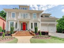 Stately home featuring a red front door, balcony, manicured lawn, beautiful flowerbeds and an attached two-car garage at 7520 Ledgewood Way, Suwanee, GA 30024