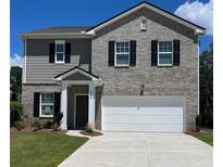 Two-story home featuring a gray brick facade, side of gray siding, and a two car garage at 2348 Argento Cir, Dacula, GA 30019