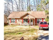 Charming single-story home with red shutters, a manicured lawn, and a welcoming front porch at 107 Honeysuckle Ln, Stockbridge, GA 30281