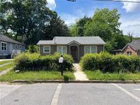 Charming single-story home with a grey roof, grey exterior, and overgrown bushes at 184 Scott Nw St, Atlanta, GA 30314