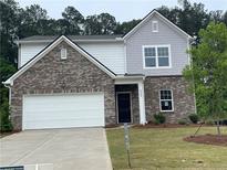 Charming two-story home featuring brick and siding exterior, a well-manicured lawn, and a two car garage at 2349 Argento Cir, Dacula, GA 30019