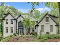 Charming painted brick home featuring professionally landscaped front yard and decorative plants on a slightly sloped lot at 2680 Spalding Dr, Atlanta, GA 30350