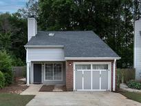 Charming home featuring brick and gray siding, complemented by a well-maintained front yard at 1903 Brittania Cir, Woodstock, GA 30188