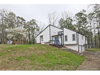 Charming renovated two-story home with a modern color scheme, landscaped yard, and inviting blue front door at 783 Lost Creek Cir, Stone Mountain, GA 30088
