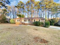 Charming brick home with a well-maintained front yard and mature trees at 2240 Spalding Dr, Marietta, GA 30062