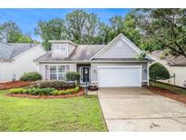 Charming single-story home with a well-maintained lawn, lovely landscaping, and attached two-car garage at 712 Brambling Way, Stockbridge, GA 30281