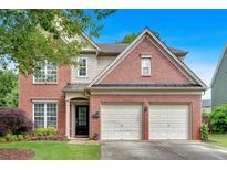 Charming two-story brick home featuring an attached two-car garage and a well-manicured front lawn at 813 Poplar Ter, Canton, GA 30115
