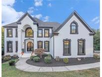 Stately two-story home featuring a white facade, black trim, arched windows, and a beautifully landscaped front yard at 4519 Mossey Dr, Lithonia, GA 30038