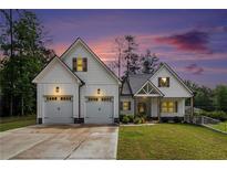 Charming two-story white farmhouse-style home with a two-car garage, well-manicured lawn, and professional landscaping at 5008 Monticello Dr, Villa Rica, GA 30180