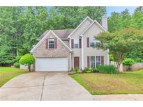 Charming two-story home featuring a brick facade, well-maintained lawn, and attached two-car garage at 307 Lee Miller Dr, Suwanee, GA 30024