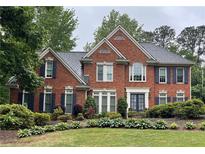 Charming two-story brick home featuring a well-manicured lawn and dark shutters at 710 Devon Hill Ct, Roswell, GA 30075