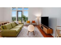 Bright living room boasts hardwood floors, modern furniture, and natural light from large windows with a view at 1195 Milton Se Ter # 1407, Atlanta, GA 30315