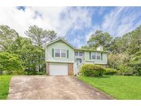 Charming two-story home with green siding, shutters, brick accents, garage and a well-maintained front yard at 2485 Shady Shoals Ct, Decatur, GA 30034