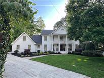 Charming two-story home featuring a balcony, brick accents, manicured lawn and a long driveway at 1042 Trailridge Pl, Atlanta, GA 30338