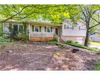 Charming home featuring a quaint front porch with green shutters, creating a welcoming facade at 230 King Arthur Dr, Woodstock, GA 30189