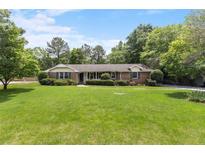 Charming single-story brick home featuring a lush green lawn and mature landscaping at 2785 Fontainebleau Dr, Dunwoody, GA 30360