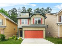Charming two-story home boasts a red garage door, green trim and a well-manicured lawn at 6571 Splitpine Ct, Atlanta, GA 30349