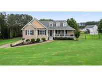 Charming home featuring manicured lawn, inviting porch, and dormer windows at 137 Cambridge Pointe, Villa Rica, GA 30180