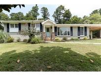Charming ranch-style home featuring a well-manicured front yard, a covered entry, and shuttered windows at 3019 Haverford Se Ln, Marietta, GA 30067