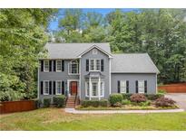 Charming two-story home with gray siding, black shutters, manicured lawn, and a welcoming front entrance at 49 Timberlake Ne Cv, Cartersville, GA 30121