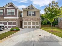 Inviting townhome featuring a brick facade, a two-car garage, and a well-manicured lawn at 44 Trailview Ln # 78, Hiram, GA 30141