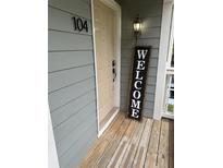 Inviting front entryway with a welcome sign, warm lighting, and a well-maintained wooden porch at 104 Abingdon Way, Atlanta, GA 30328