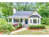 Charming home featuring a landscaped front yard, inviting porch, and classic architectural details at 138 Hartwood Dr, Woodstock, GA 30189