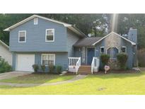 Charming two-story home with blue siding, stone accents, and a well-maintained front yard at 604 Pepperwood Ln, Stone Mountain, GA 30087
