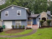 Charming two-story home with blue siding, stone accents, and a well-maintained front yard at 604 Pepperwood Ln, Stone Mountain, GA 30087