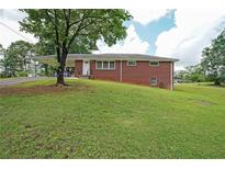 Charming brick home featuring a covered carport and a well-maintained front lawn at 629 Birchwood Rd, Marietta, GA 30060