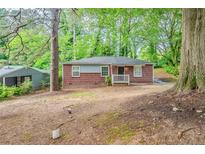 Charming brick home featuring a cozy front porch and surrounded by mature trees at 3731 Adkins Nw Rd, Atlanta, GA 30331