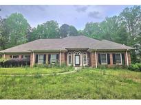 Charming one-story brick home featuring a well-manicured front yard and a welcoming entrance at 4855 West Price Rd, Sugar Hill, GA 30518