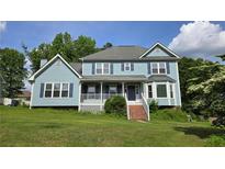 Charming two-story home with light blue siding, inviting front porch, and well-maintained lawn at 4905 Puritan Dr, Sugar Hill, GA 30518