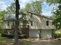 Charming exterior elevation with stone accents, two-car garage, and a wooden deck at 6070 Ridge Way, Douglasville, GA 30135