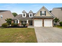 Charming single-Gathering home boasts a manicured lawn and a two-car garage with stone accents at 2586 Gristhaven Ln, Buford, GA 30519