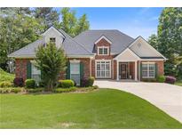 Charming brick home featuring a manicured lawn, lush landscaping, and a welcoming front porch at 5791 Epping Ct, Douglasville, GA 30135