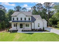 Charming two-story home featuring a welcoming front porch with wooden beams and professionally landscaped front yard at 10350 Alvin Rd, Johns Creek, GA 30022