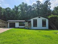 Charming renovated home with a freshly painted white brick exterior, dark trim, and a well-maintained green lawn at 2400 Glenrock Dr, Decatur, GA 30032