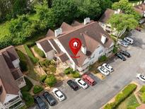 Aerial view of property with ample parking, mature trees, and architectural roof detail at 904 Bridge Se Ln, Smyrna, GA 30082