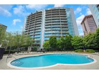 Stunning building featuring a pristine pool with ample lounge seating and well-maintained landscaping at 44 Peachtree Nw Pl # 2024, Atlanta, GA 30309
