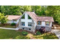 Beautiful home featuring a stone and white facade with large windows and a well-manicured lawn at 3222 Bay View Dr, Jonesboro, GA 30236