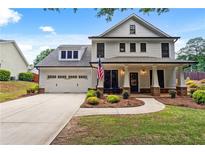 Charming two-story home with a well-manicured lawn, attached two-car garage, and a welcoming front porch with columns at 4092 Grand Park Dr, Suwanee, GA 30024
