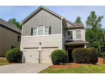 Charming two-story home features a two-car garage, neutral siding and manicured landscaping at 4605 Fourth Rail Ln, Cumming, GA 30040