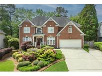 Stately brick home with beautifully landscaped front yard and attached two-car garage at 6317 Benbrooke Overlook Nw, Acworth, GA 30101