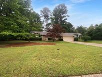 Charming single story home featuring a lush front yard, mature shade trees, and a covered front porch at 2060 Devore Sw Dr, Marietta, GA 30008