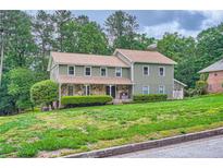 Charming two-story home with stone accents and a well-manicured front yard at 4826 Dean Sw Ln, Lilburn, GA 30047