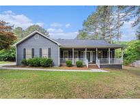 Charming single-story home with a welcoming front porch and well-maintained landscaping at 325 N Oakland Cir, Mcdonough, GA 30253