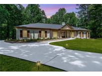 Charming single-story home featuring a concrete driveway and meticulously maintained landscaping and flowerbeds at 140 Emily Sw Dr, Lilburn, GA 30047