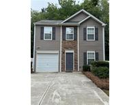 Charming two-story home featuring gray siding, stone accents, and a single-car garage at 218 Osmanthus Way, Canton, GA 30114